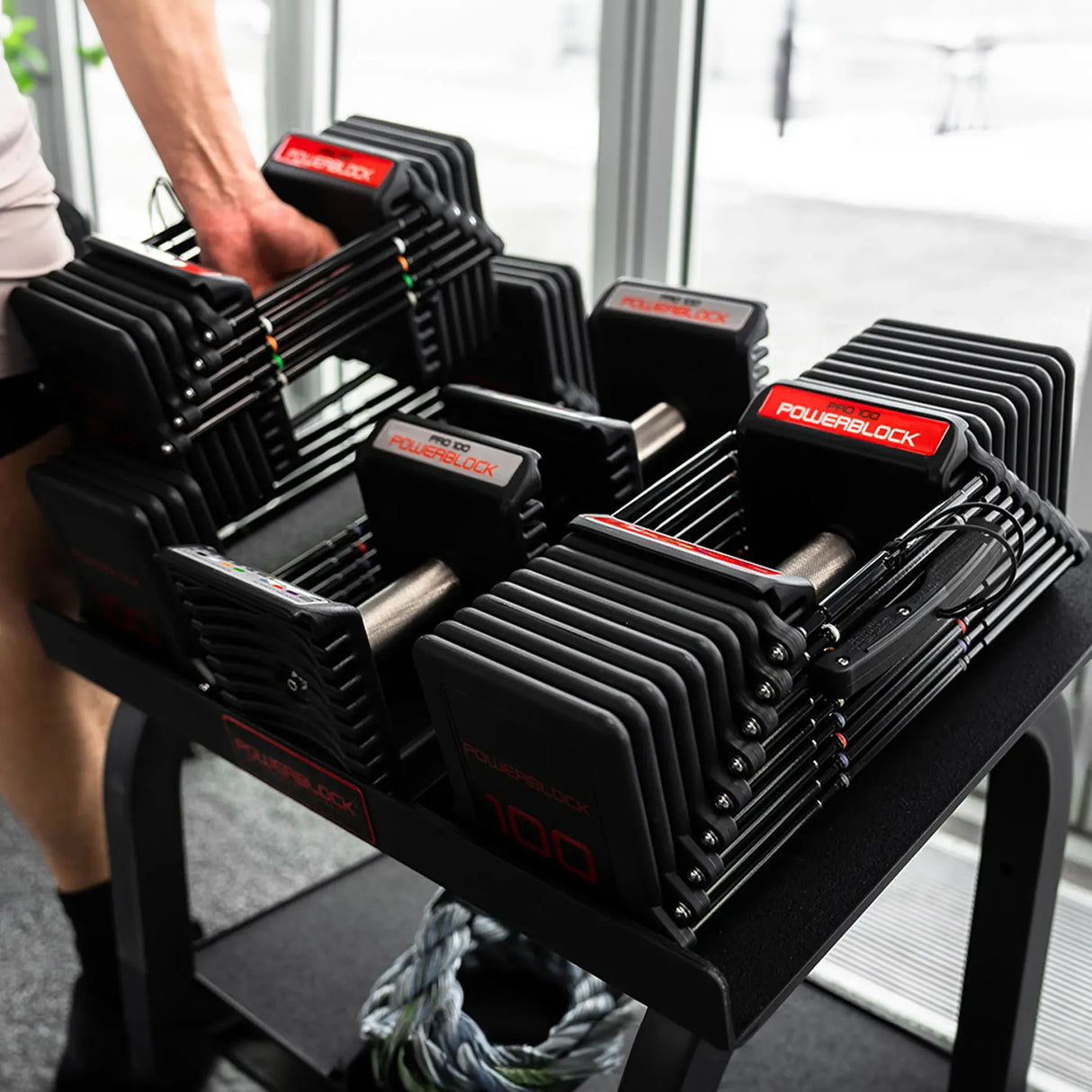 A person lifting up a PowerBlock Commercial Pro 100 Dumbbell