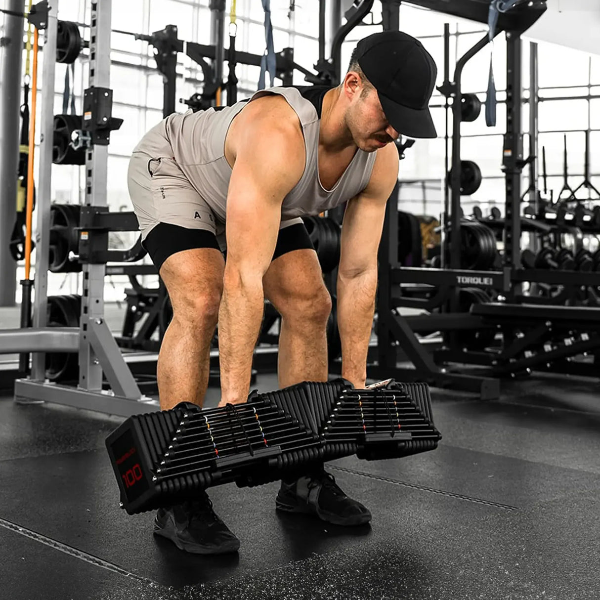 A man doing straight legged deadlifts with a pair of PowerBlock Commercial Pro 100 Dumbbells