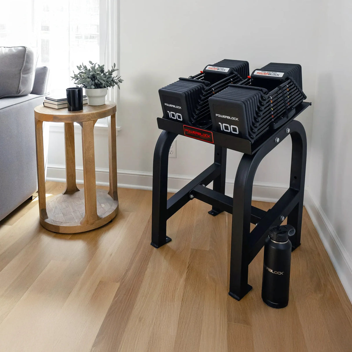 A PowerBlock Home Rack Stand with dumbbells on it