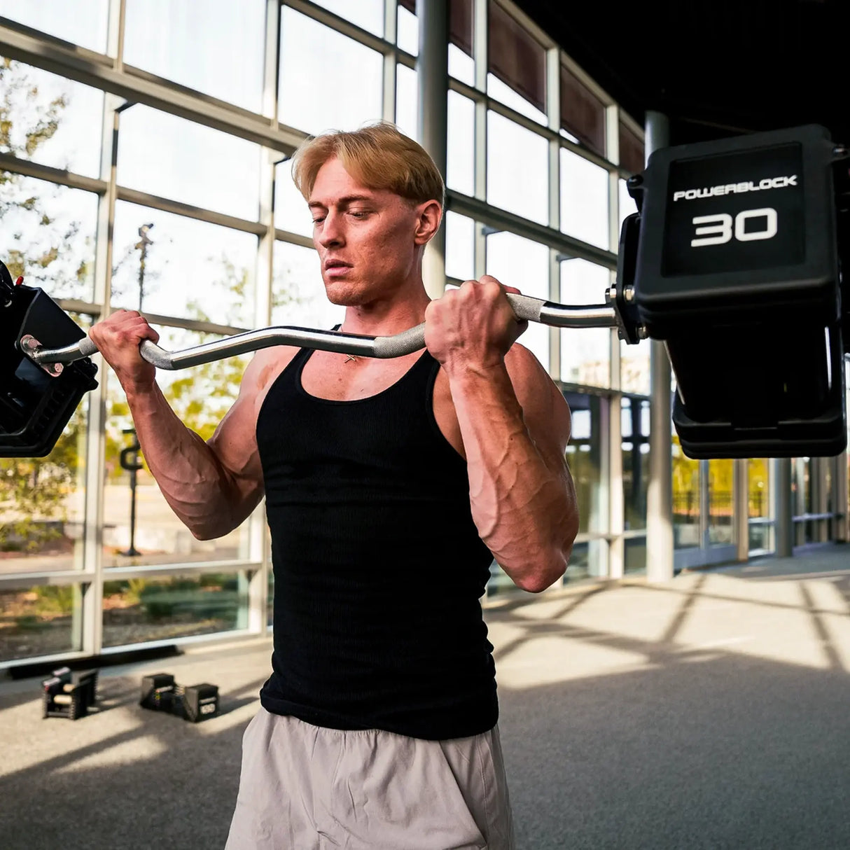 Man curling a PowerBlock EZ barbell