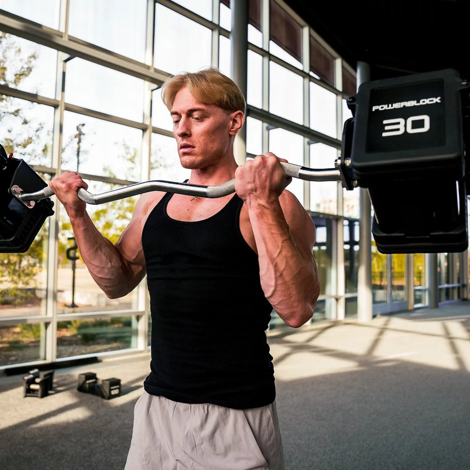 Man curling a PowerBlock EZ barbell