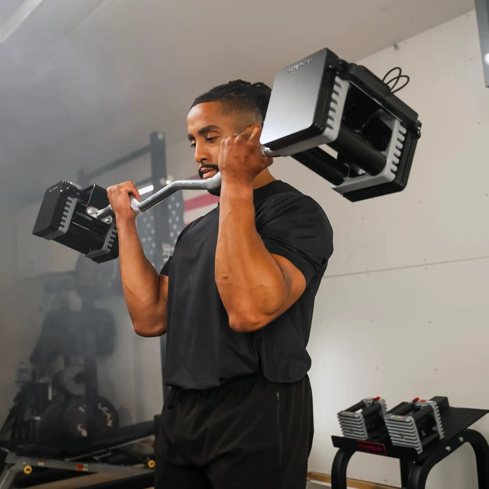 Man curling a PowerBlock EZ barbell