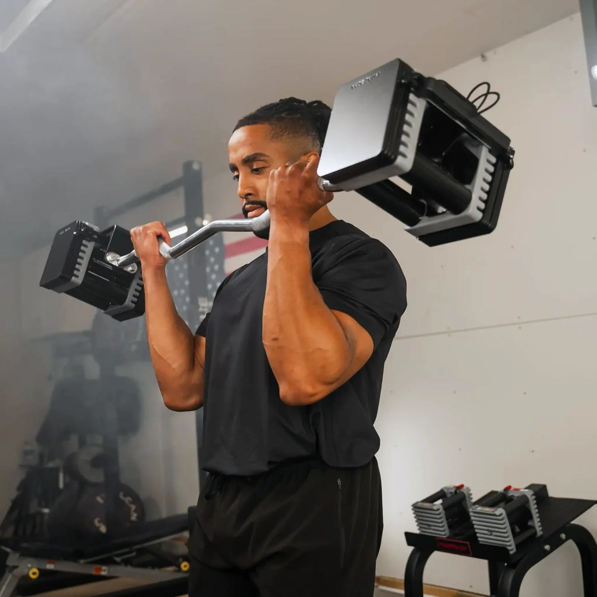 Man curling a PowerBlock EZ barbell