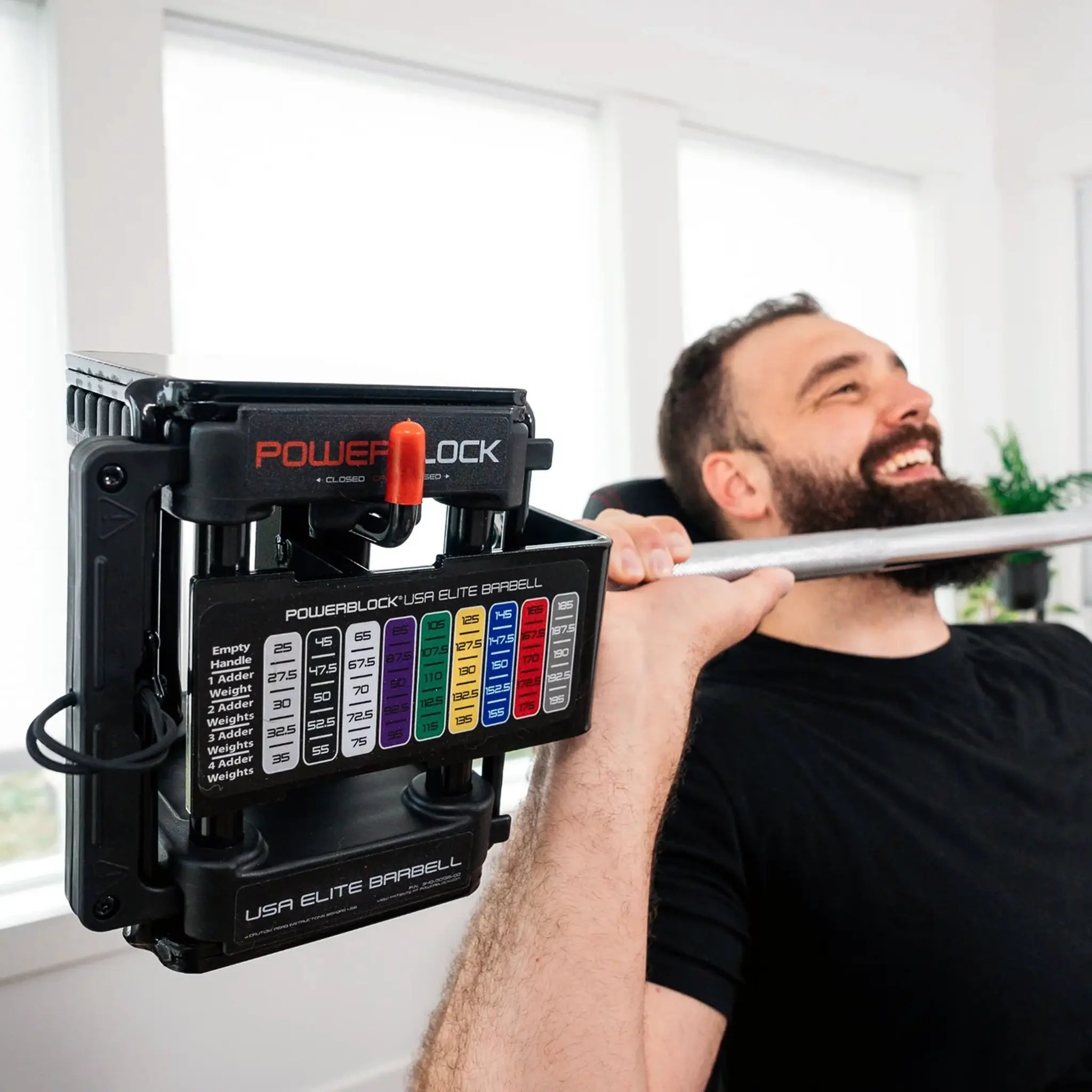 Man pressing a PowerBlock straight barbell