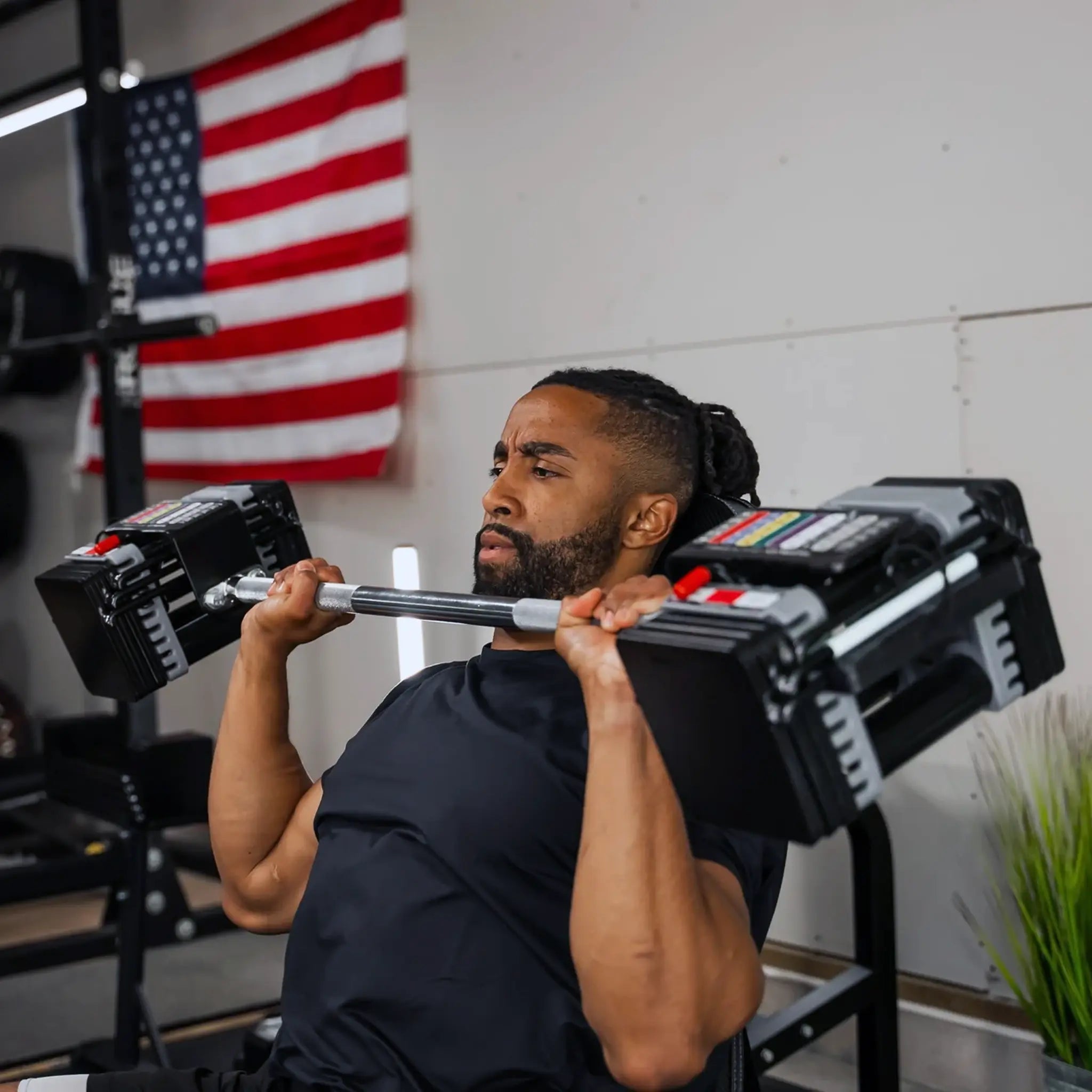 Man pressing a PowerBlock straight barbell