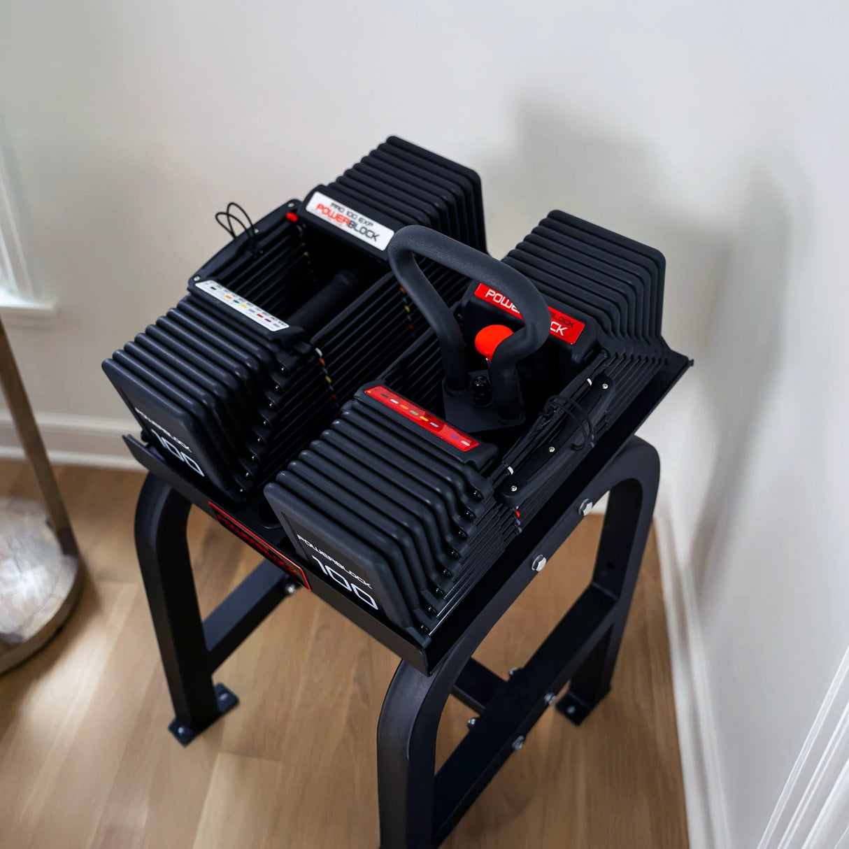 A PowerBlock Home Rack Stand with dumbbells on it
