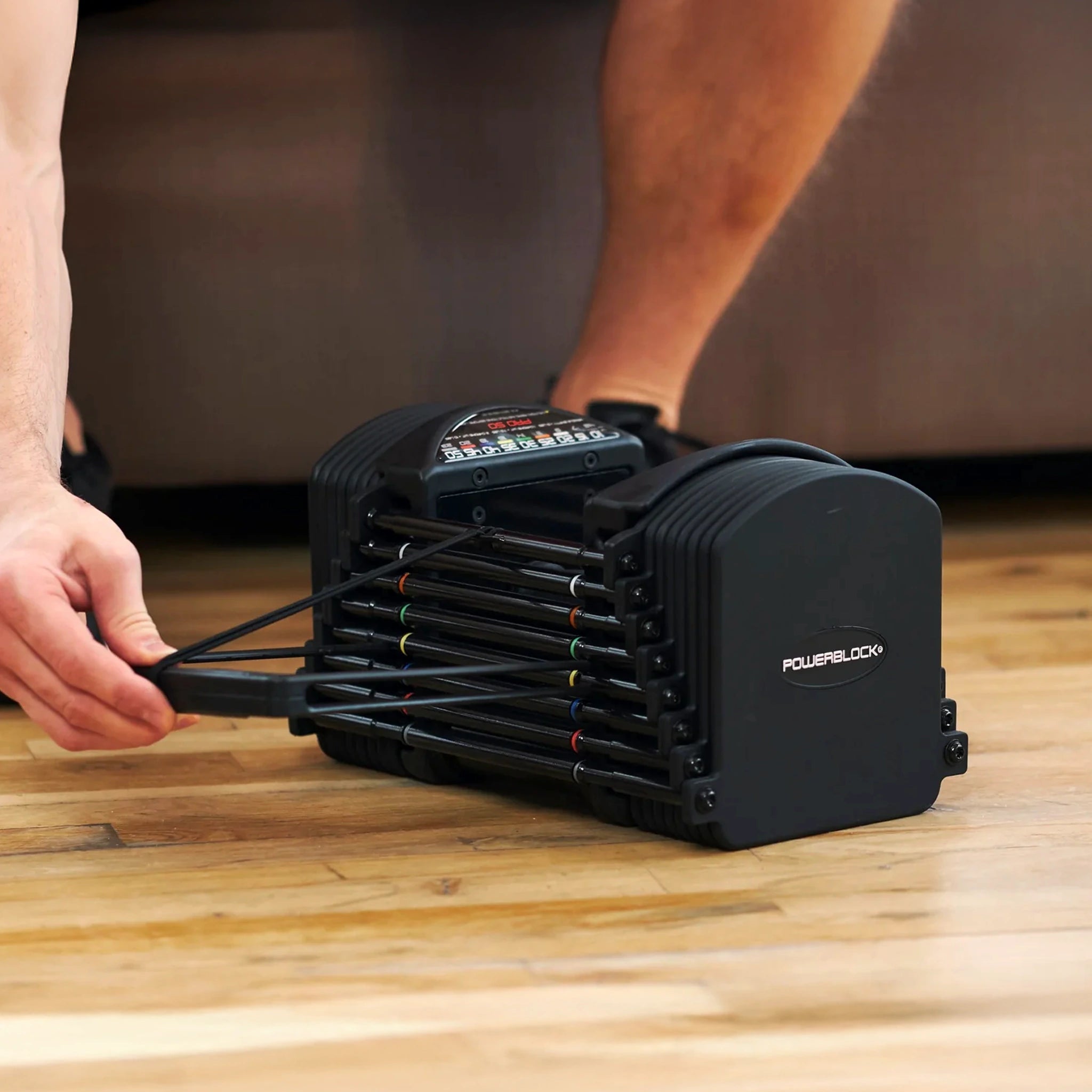 Someone adjusting the selector pin on a PowerBlock Pro 50 Dumbbell