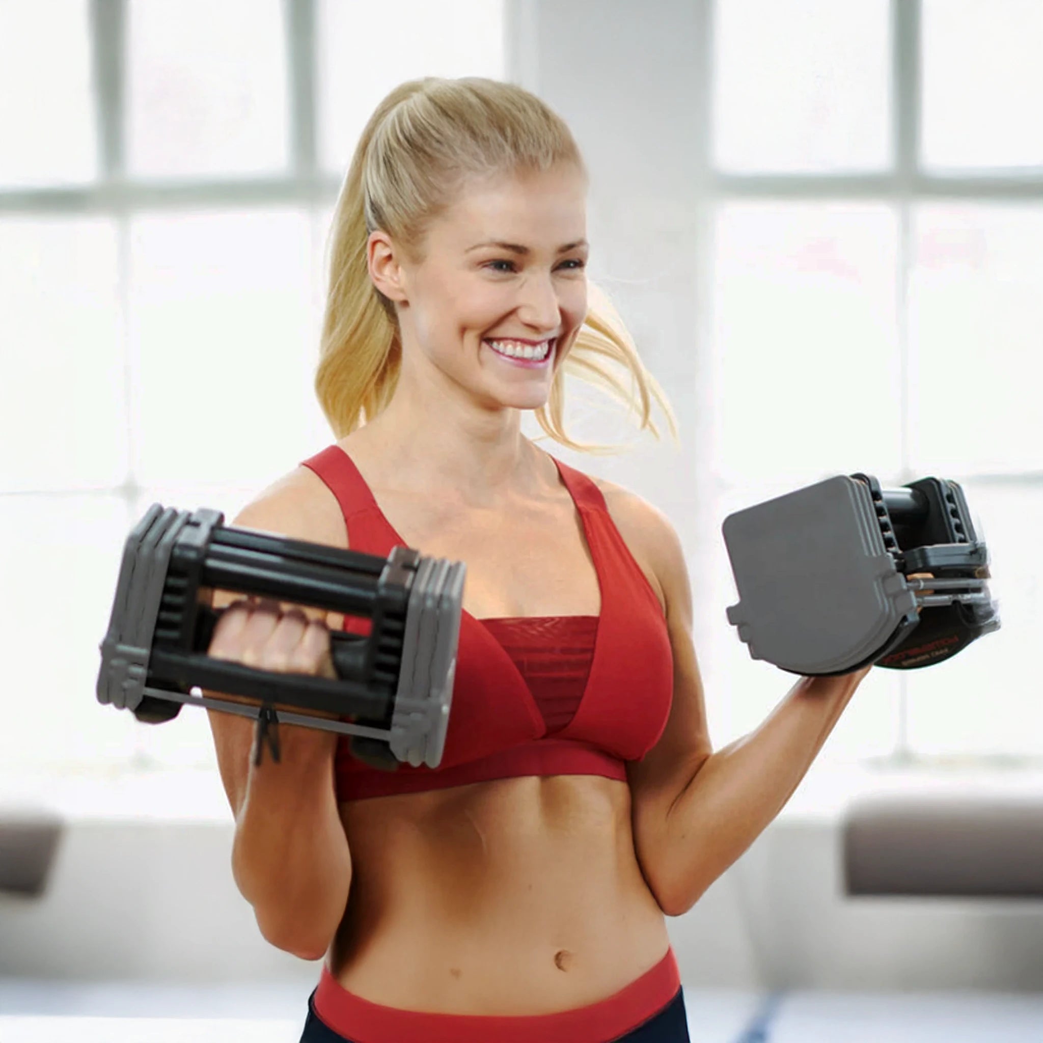 A woman curling a pair of PowerBlock Sport 24 Dumbbells