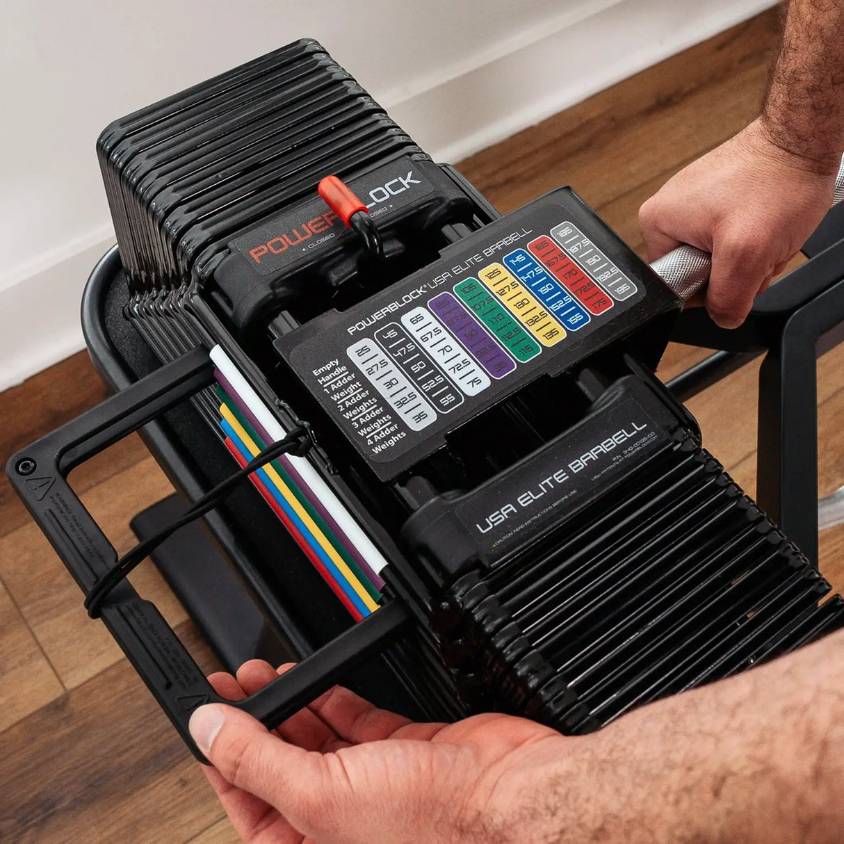 Man changing the weight on a PowerBlock straight barbell