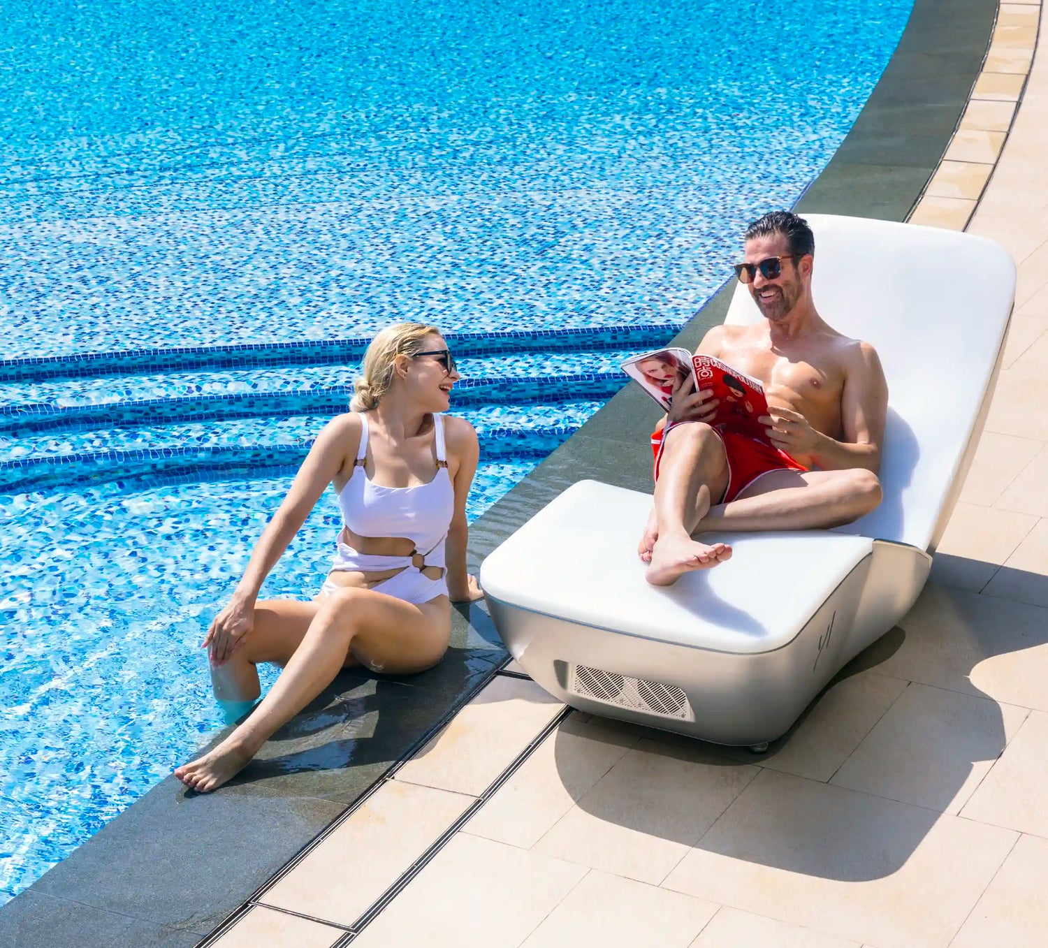 Man lounging on ergonomic red light infrared therapy bed next to pool