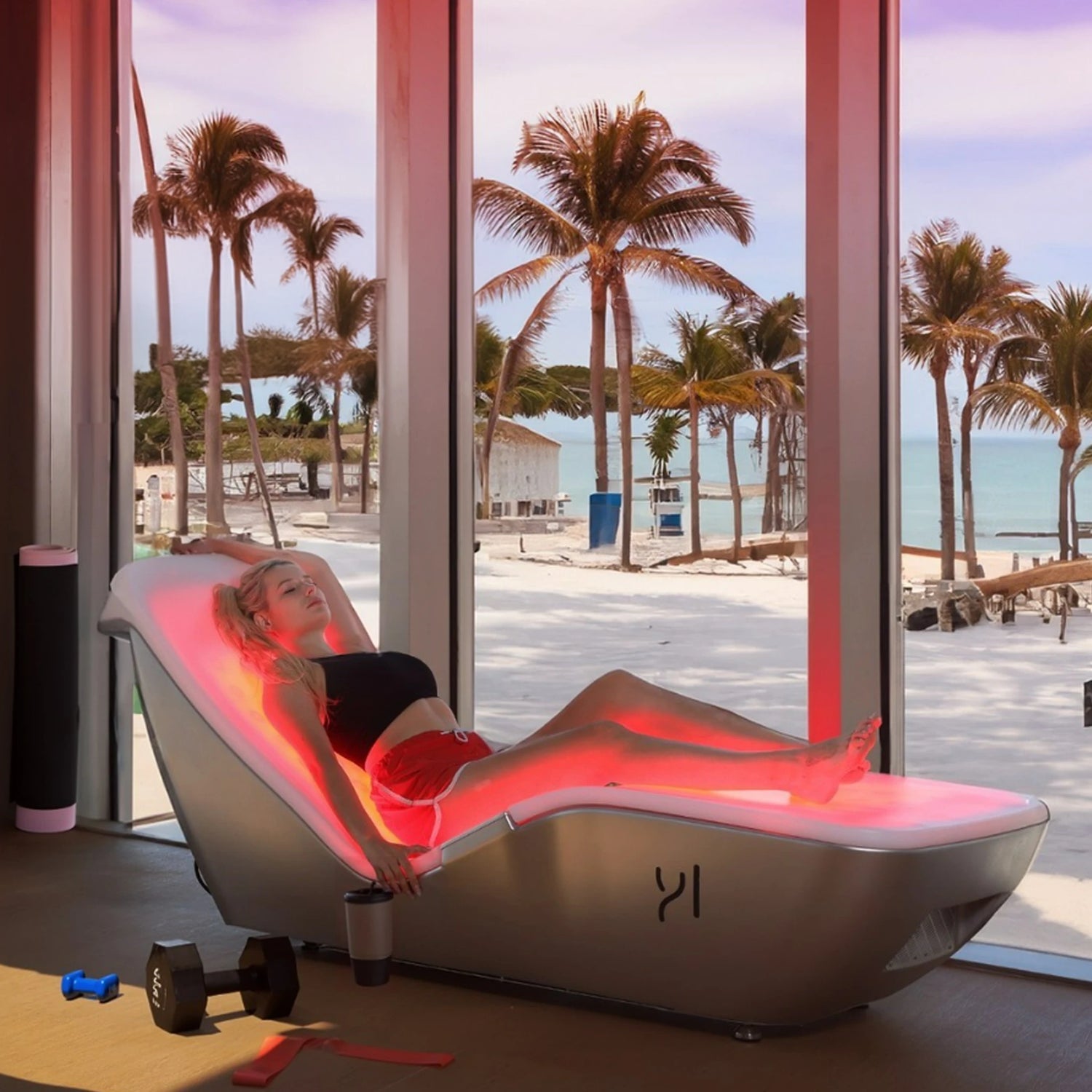 Woman laying on red light infrared therapy bed in a  gym