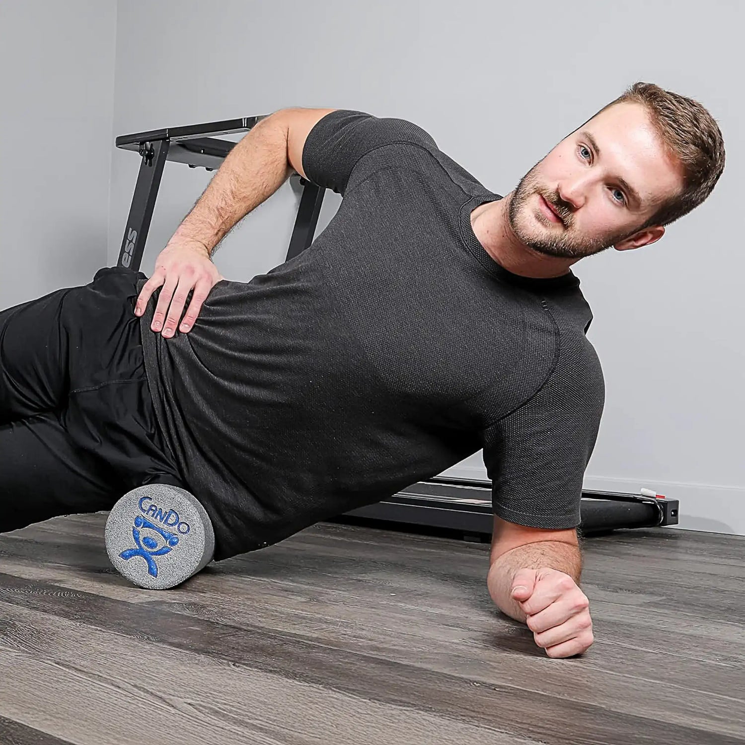 Man rolling hip on open cell foam short foam roller by CanDo