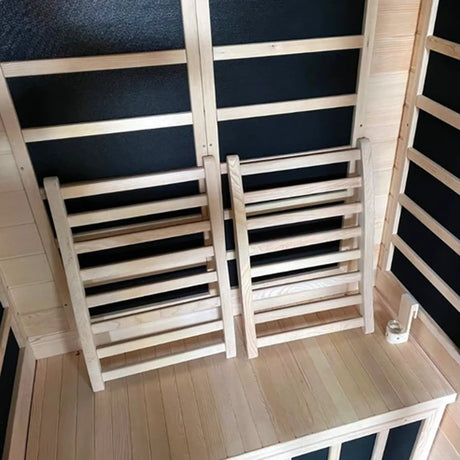 Two wooden backrests with parallel wooden rungs inside of a sauna