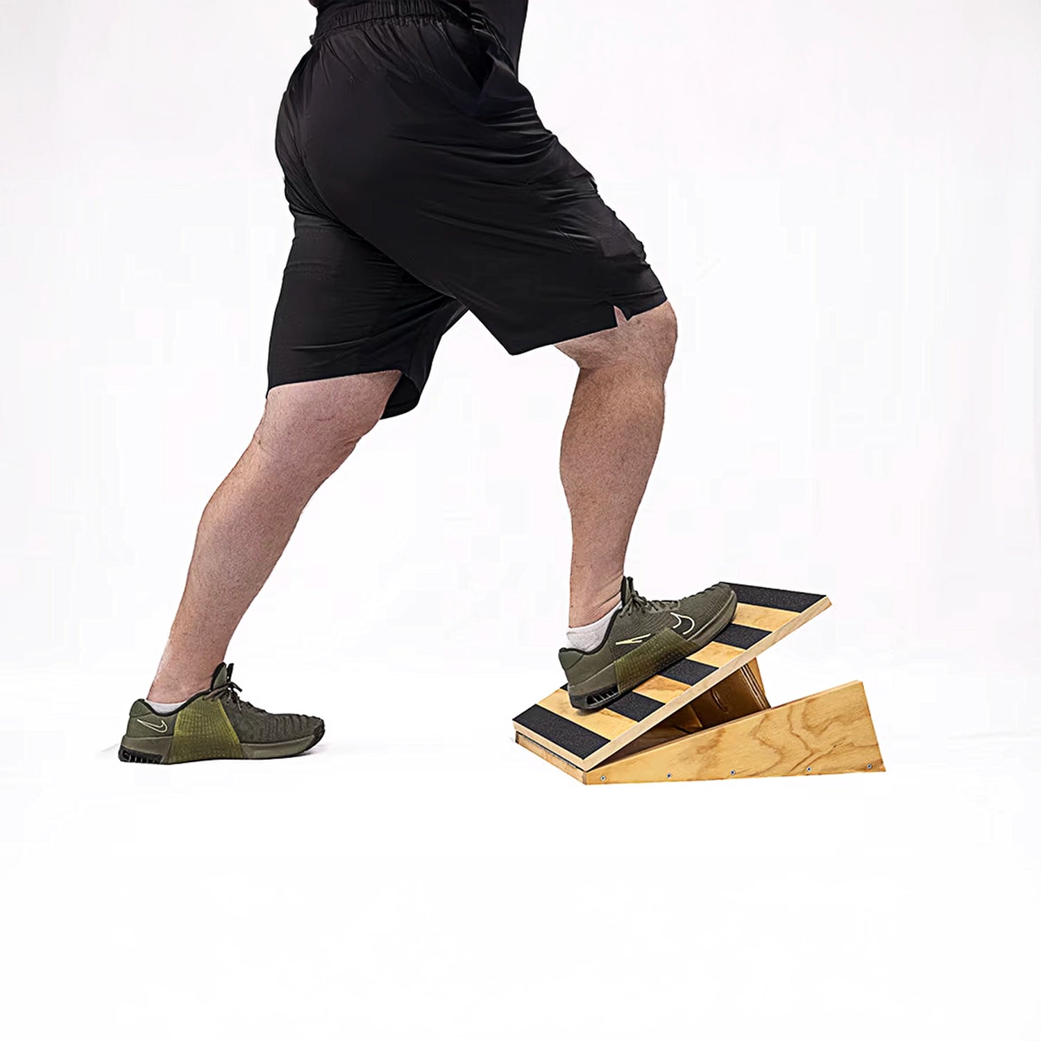 Man stretching on wooden adjustable slant board with grip tape by Perform Better