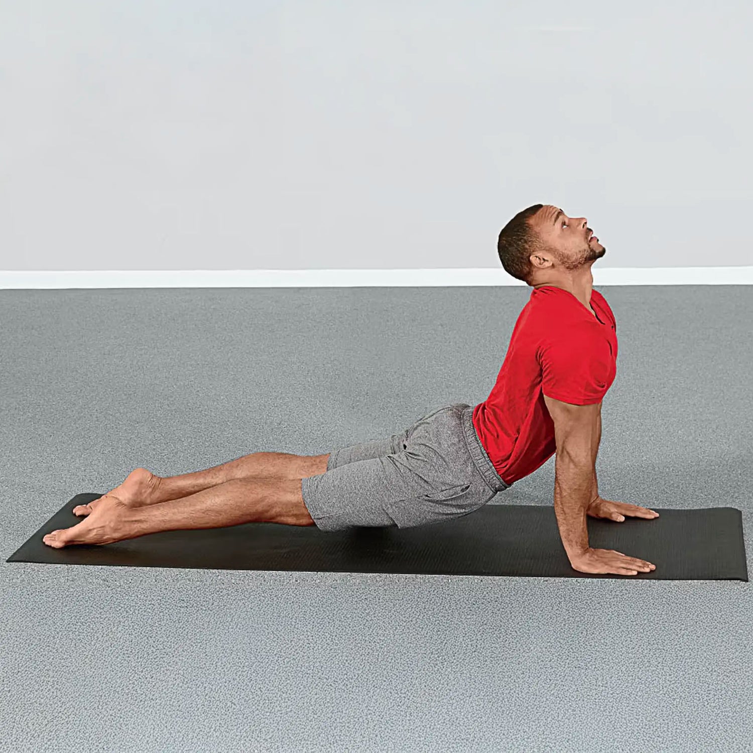 Man stretching on premium black yoga mat by Perform Better