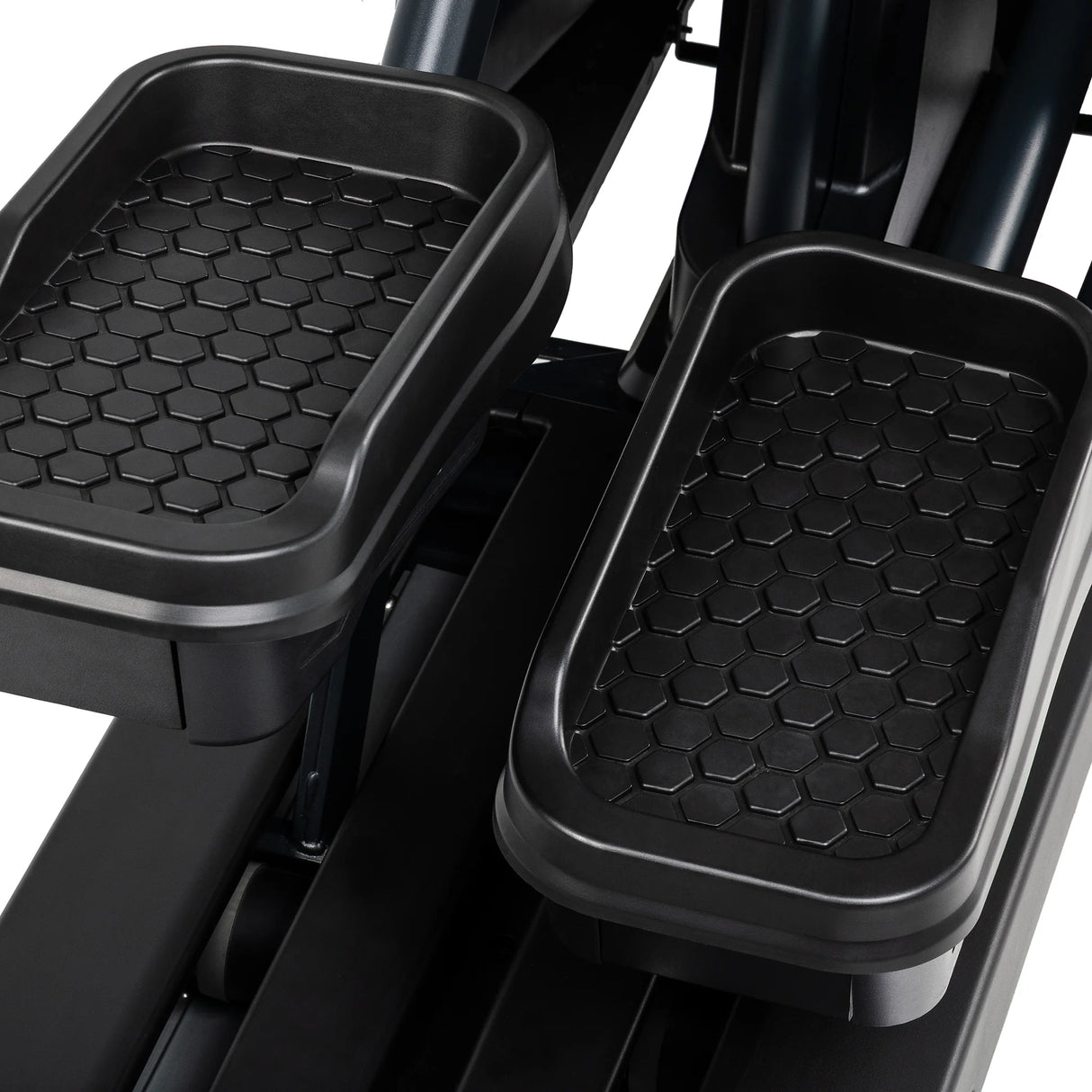 Close-up of the Spirit Fitness CE1000ENT Elliptical foot platforms shows the textured hexagonal, non-slip grip surface on both pedals.