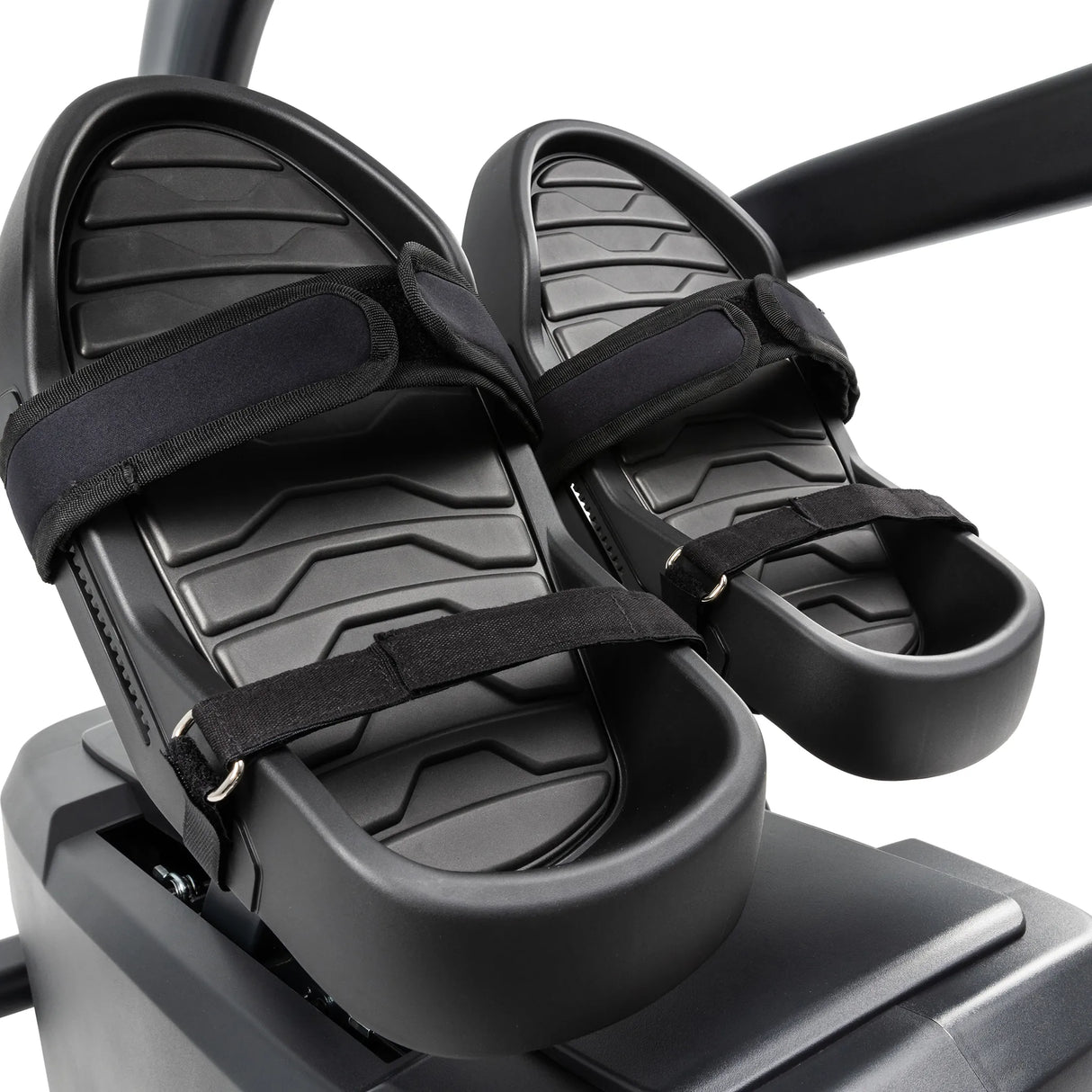 Close-up of two black textured foot pedals with adjustable straps on the Spirit Fitness CRS800S Recumbent Seated Stepper by Spirit Fitness, set against a plain background.