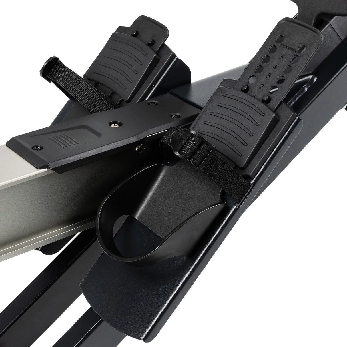Close-up of adjustable footrests with straps on the Spirit Fitness CRW800 Rower, featuring textured footplates and a section of the sturdy metal rail.