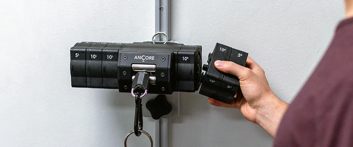 Man adding adder plates to an ANCORE wall-mounted portable cable machine.