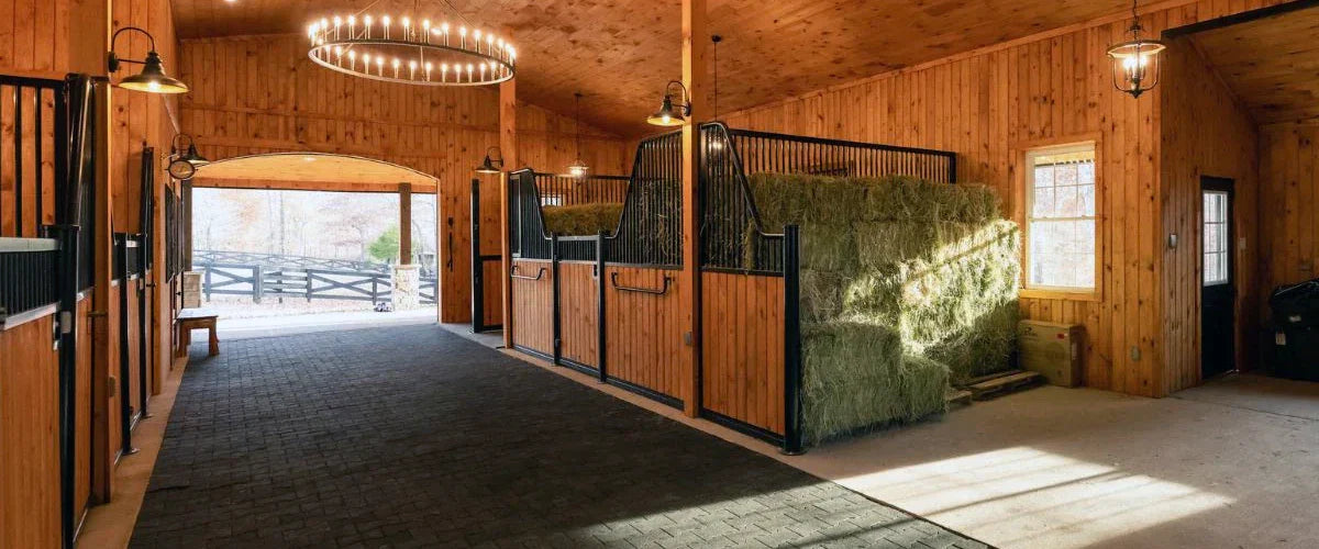 a new high end wooden horse barn with rubber pavers running down the middle aisle. 