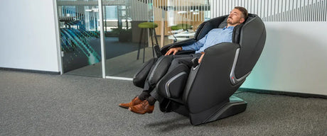 Man sitting in a massage chair in an office setting with his eyes closed
