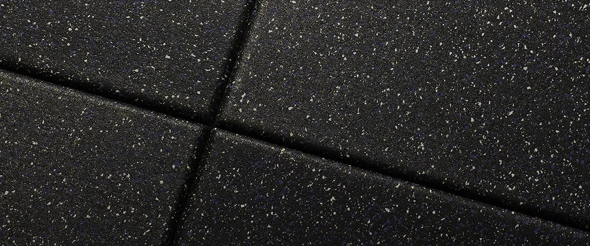Closeup image of black rubber floor tiles with white specks
