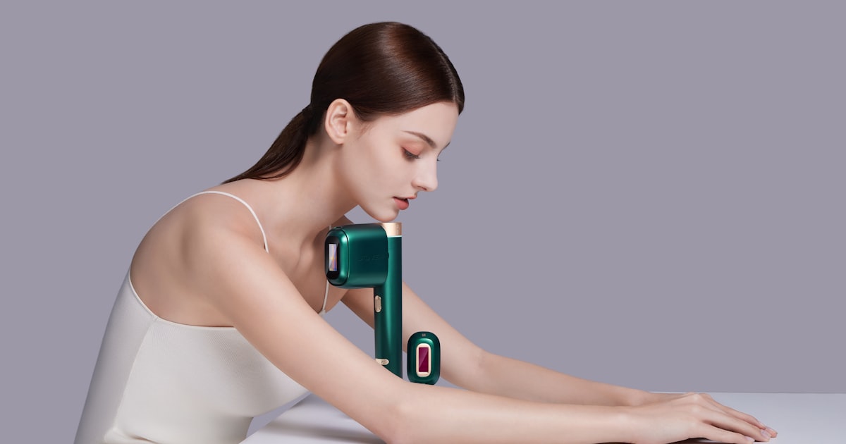 a woman sitting at a table with a device in her hand