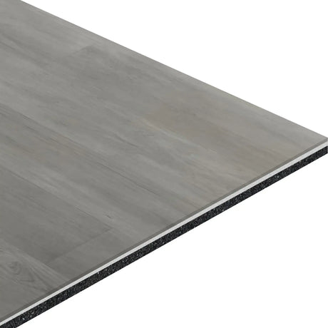 A close-up of the ECORE Baller Motivate Laminate Roll - 7mm Class 1 Flooring by ECORE Athletic shows its rectangular, gray plank with wood grain texture, layered construction, and black core material along the edge.