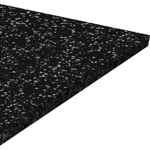 A close-up view of the ECORE Athletic Performance Beast Rubber Roll - 10.5mm Flooring, a rectangular black mat with white speckles, shown at an angle to highlight its thickness and textured surface.