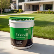 Ecore E-Grip III Flooring Adhesive container with a house and lawn in the background