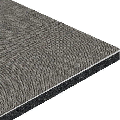 A close-up of the ECORE Athletic Ebb & Flow Motivate Laminate Roll - 6mm Class 1 Flooring shows its layered structure: a gray, textured fabric surface atop a black, speckled foam-like layer.