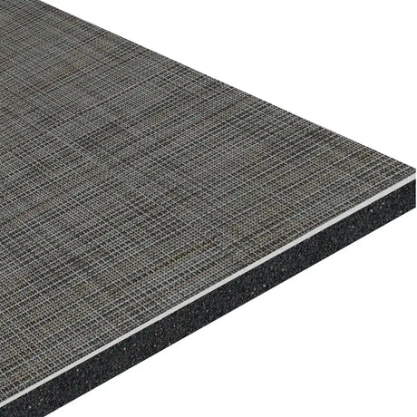 A close-up of ECORE Ebb & Flow Motivate Laminate Roll - 6mm Class 1 Flooring by ECORE Athletic shows its rectangular panel design with a textured gray woven top, thin white middle, and thick black bottom layers, highlighting its layered construction.