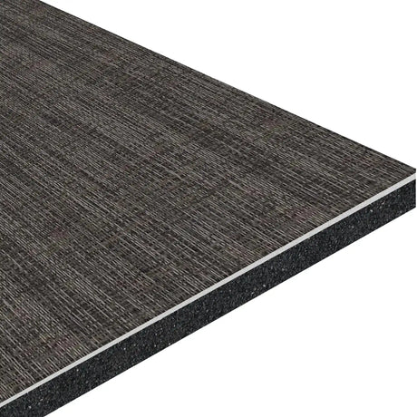A close-up of the ECORE Athletic ECORE Ebb & Flow Motivate Laminate Roll - 6mm Class 1 Flooring shows its dark textured surface and multi-layered structure, featuring a black core and lighter inner layers.