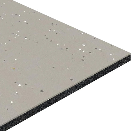 A close-up of ECORE Athletic’s Integrity Motivate Laminate Roll - 7mm Class 1 Flooring shows a gray surface with white and black speckles and a layered cross-section featuring a dark base.