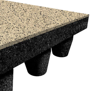 A close-up of a corner of the ECORE PlayGuard Rubber Tile - 2.5" Playground Flooring by ECORE Athletic shows a speckled beige surface, thick black core, and several black cylindrical supports underneath.