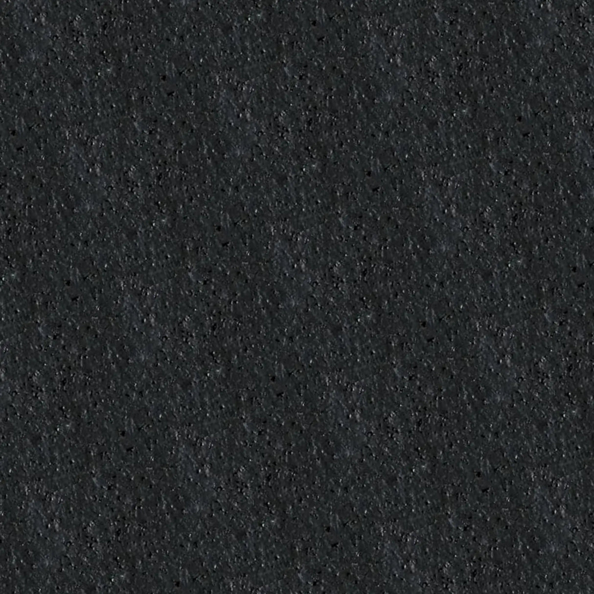 A close-up of ECORE Athletic's PlayGuard Rubber Tile - 2.5" Playground Flooring reveals its black, rough, textured, and slightly speckled rubber surface.