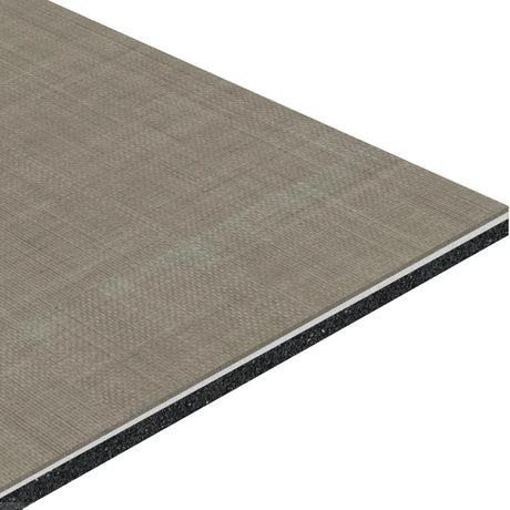 An angled close-up of the ECORE Serenity Motivate Laminate Roll - 7mm Class 1 Flooring by ECORE Athletic, showing its textured gray top, thin white middle layer, and dark gray or black core.