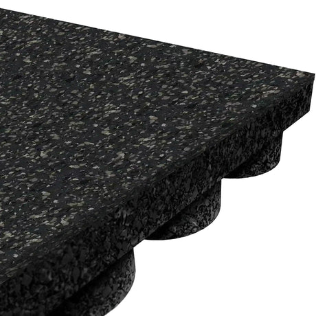 Angled close-up of an ECORE Performance UltraTile - 1" Rubber Tile by ECORE Athletic, featuring a black speckled textured surface and rounded, raised support structures on the underside, set against a white background.