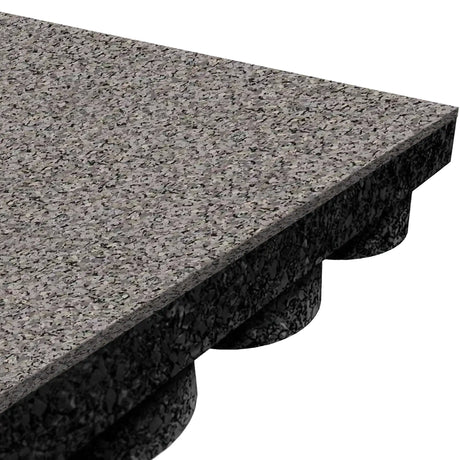 A close-up of the ECORE Performance UltraTile - 1" Rubber Tile by ECORE Athletic, featuring a gray, speckled texture with a layered edge and wavy, elevated underside, resembling a modular floor or paving tile.