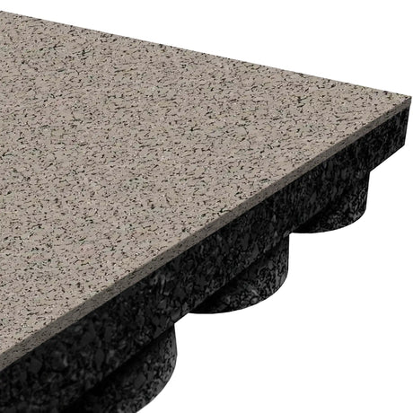 Close-up of an ECORE Athletic Performance UltraTile - 1" Rubber Tile: rectangular, speckled gray with a textured surface and black, grooved underside, displayed at an angle against a white background.