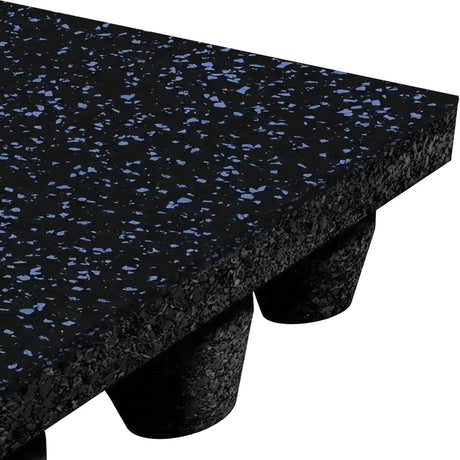 Close-up of the ECORE Athletic Performance dBTile Rubber Tile 2.5" Acoustic Flooring—thick black mat with small blue specks, shown on short cylindrical legs against a white background.