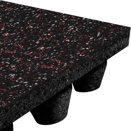 Close-up of the ECORE Performance dBTile Rubber Tile - 2.5" Acoustic Flooring by ECORE Athletic: a thick, black rubber gym tile with red and gray speckles, textured surface, and raised round support feet for shock absorption.