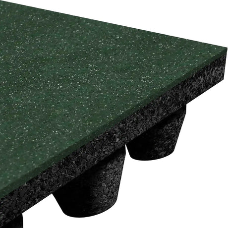 Close-up of the ECORE Performance dBTile Rubber Tile – 2.5" Acoustic Flooring by ECORE Athletic, showing its thick green, textured surface and underside with black cylindrical supports that elevate the mat off the ground.