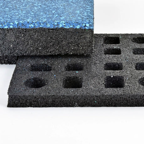 Two thick black rubber mats from ECORE Athletic are shown. One features a smooth blue-speckled top; the other is an ECORE Quad Blok Connector for 2.5" Tiles with a grid of square cut-out holes. Both have a textured, spongy look.