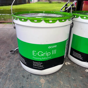 Two buckets of ecore E-Grip III Flooring Adhesive on a concrete surface.