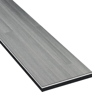 A close-up of the ECORE Heritage Motivate Vinyl Plank by ECORE Athletic highlights its gray wood grain texture and layered 7mm PVT Performance Flooring construction.