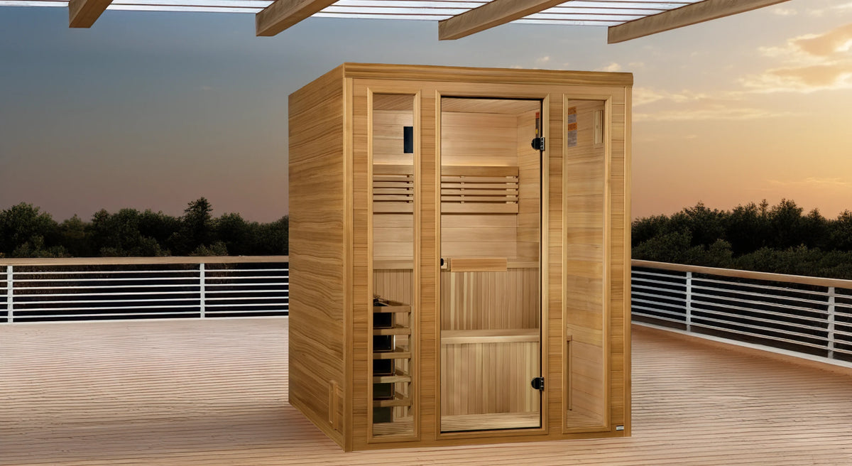 Golden Designs Andermatt model sauna with a 3 person capacity constructed from Pacific cedar wood inside and out positioned on a covered deck at sunset