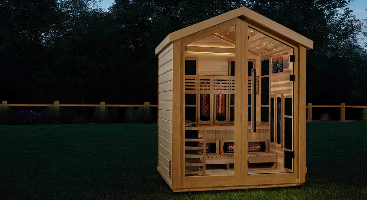 Golden Designs Loviisa hybrid model sauna featuring full spectrum infrared and traditional steam technology with star galaxy overhead lighting made from Canadian red cedar interior and an all weather composite exterior with a three person capacity built for outdoor use positioned on a green backyard lawn at nigh