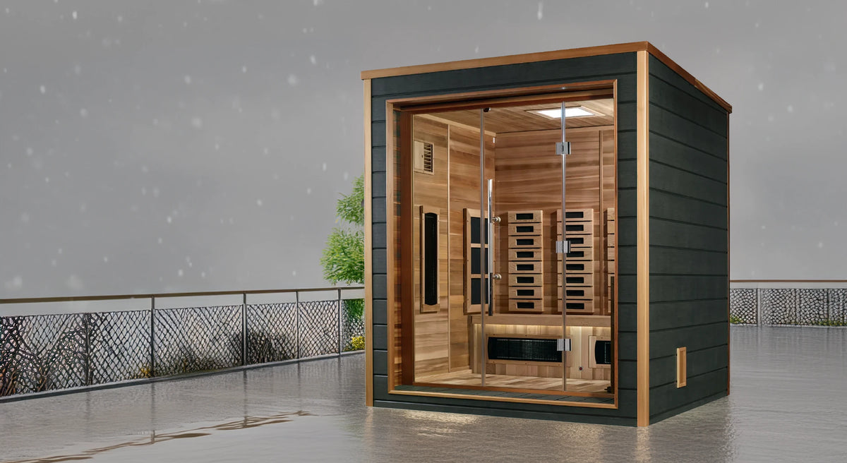 Golden Designs Visby model sauna featuring hybrid technology which emits full spectrum infrared heat and traditional steam heat and has a three person capacity and is constructed from Canadian red cedar wood on the interior and an all weather composite material on the exterior making it great for outdoor use in all climates pictured on a rainy deck