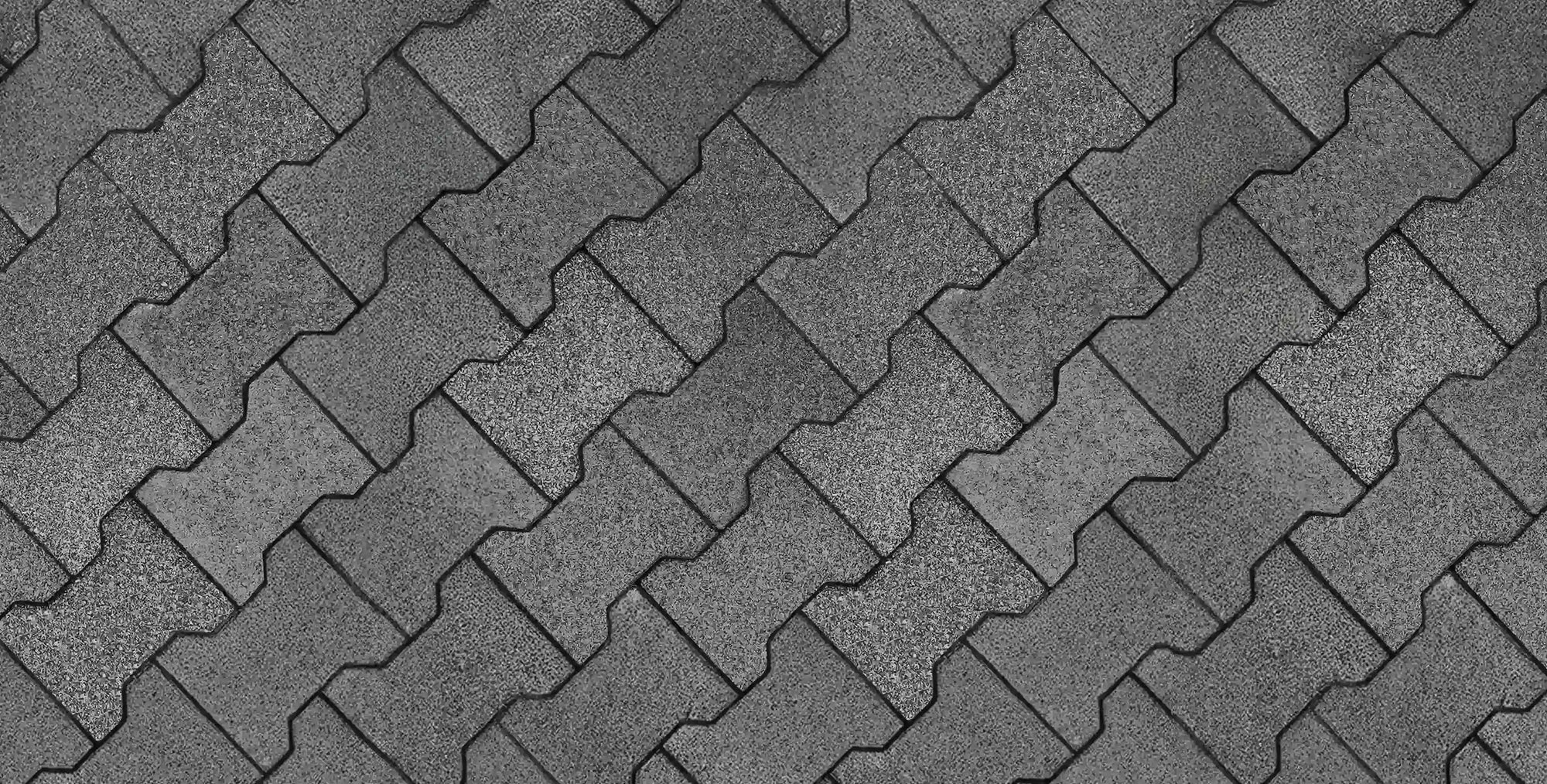 An overhead top-down view of a floor made from gray rubber pavers in an interlocking pattern